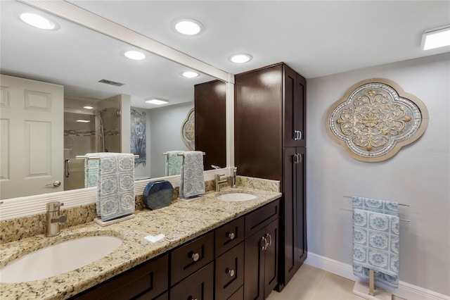 full bath featuring double vanity, a sink, visible vents, and a shower stall