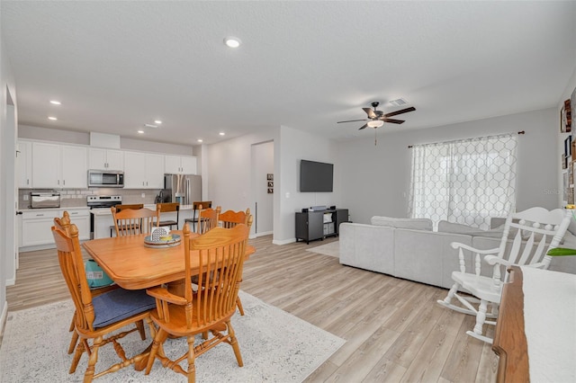 dining area featuring a textured ceiling, light wood finished floors, a ceiling fan, and recessed lighting