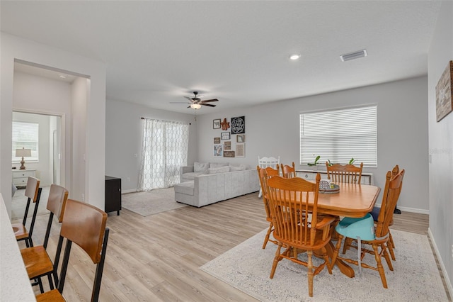 dining area with baseboards, ceiling fan, visible vents, and light wood-style floors