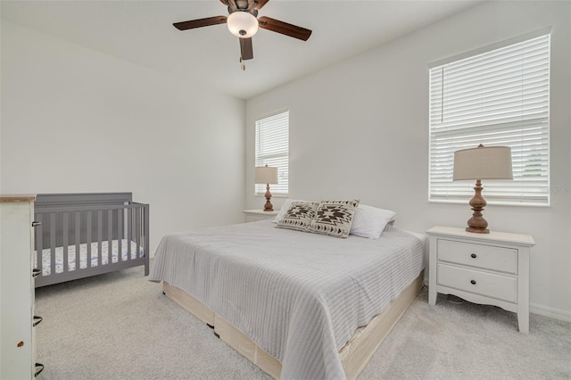 bedroom with baseboards, a ceiling fan, and light colored carpet