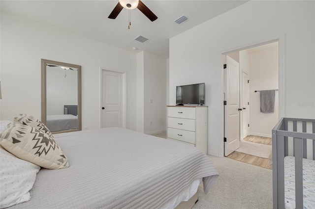 bedroom featuring a ceiling fan, visible vents, light wood-style flooring, and baseboards