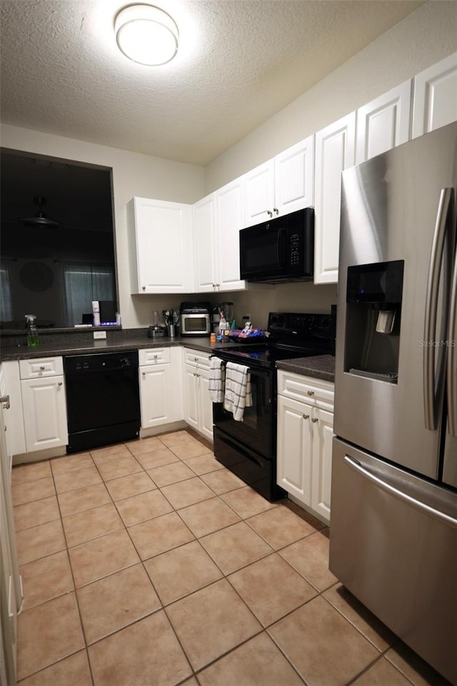 kitchen featuring dark countertops, white cabinets, and black appliances