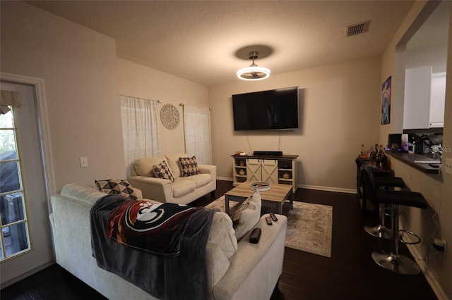 living room with visible vents, dark wood finished floors, and baseboards