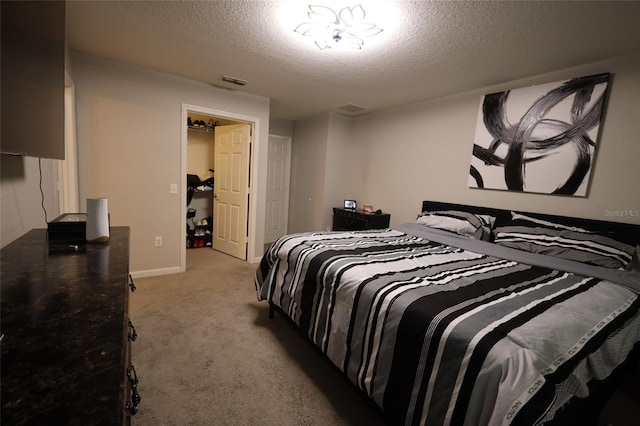 bedroom featuring baseboards, visible vents, a textured ceiling, and light colored carpet