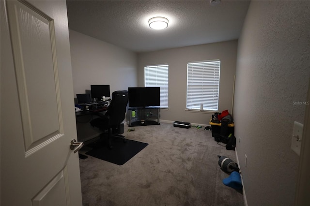 home office with a textured ceiling, a textured wall, carpet flooring, and baseboards