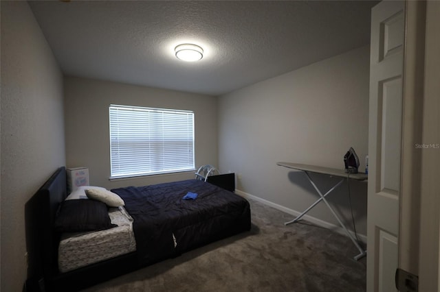 carpeted bedroom featuring a textured ceiling and baseboards