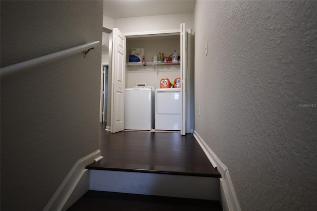 laundry room featuring laundry area, dark wood-style floors, a textured wall, and washing machine and clothes dryer