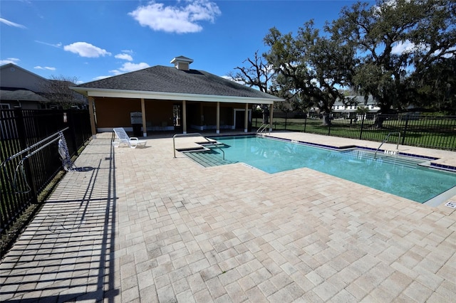 community pool with a patio area and fence