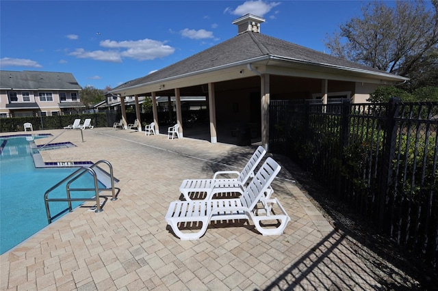 view of patio featuring a community pool and fence