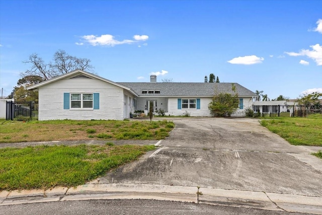 ranch-style home featuring fence, a chimney, and a front lawn