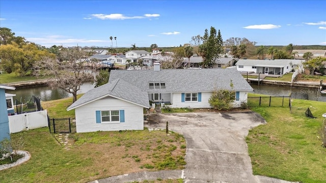 ranch-style house featuring a water view, a gate, a residential view, and a front yard