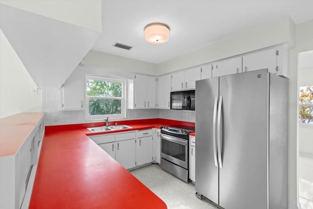 kitchen featuring appliances with stainless steel finishes, backsplash, a sink, and visible vents