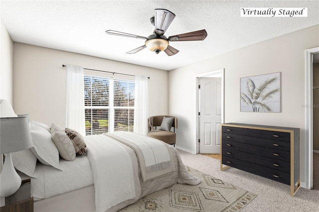 bedroom with light colored carpet, ceiling fan, a textured ceiling, and baseboards