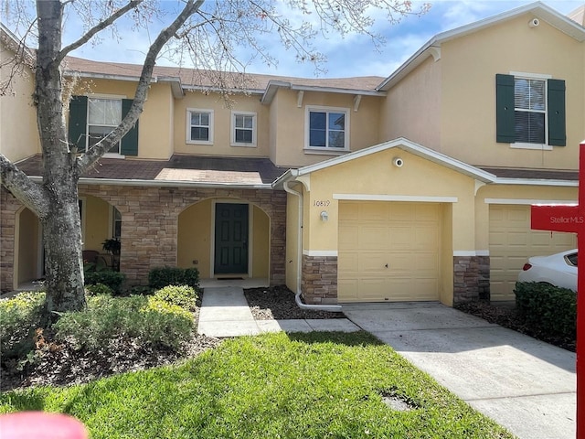 multi unit property with covered porch, concrete driveway, stone siding, and stucco siding