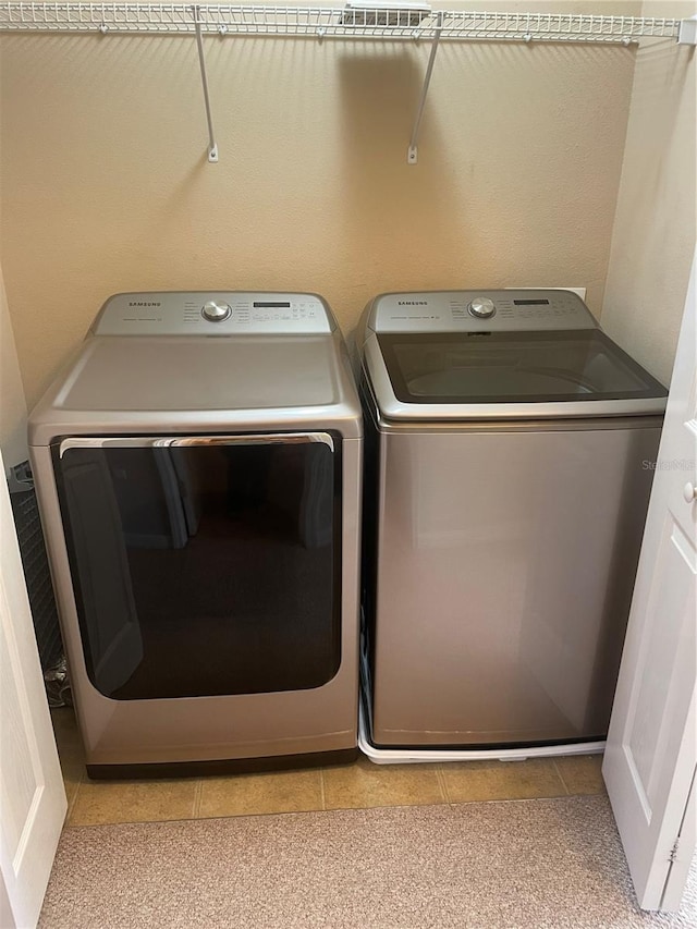 laundry area featuring laundry area, washer and clothes dryer, and light tile patterned floors