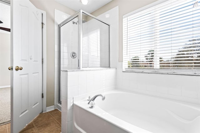 full bathroom with a shower stall, a bath, and tile patterned floors