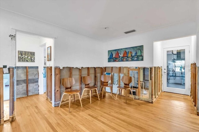 living area with visible vents and wood finished floors