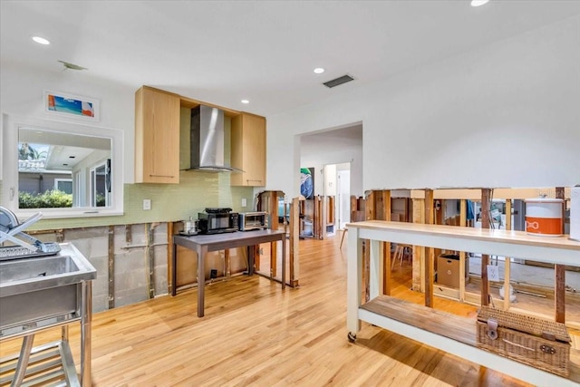 kitchen with tasteful backsplash, recessed lighting, visible vents, light wood-style flooring, and wall chimney range hood