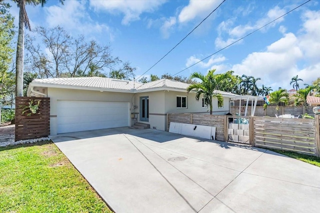 ranch-style home featuring a garage, concrete driveway, a tiled roof, fence, and stucco siding