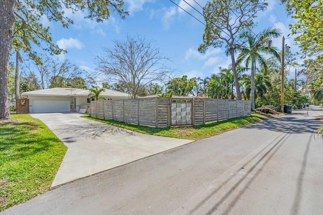 exterior space with a fenced front yard, driveway, and an attached garage