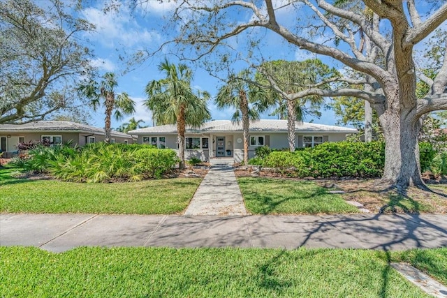 ranch-style house with stucco siding and a front yard