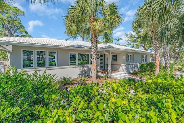 single story home featuring a tile roof and stucco siding