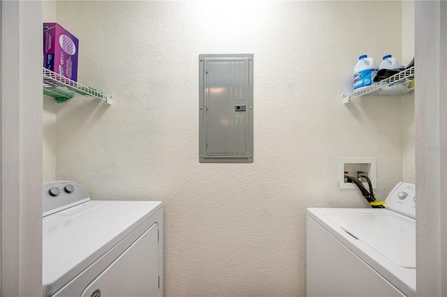 laundry room featuring washer and dryer, laundry area, electric panel, and a textured wall