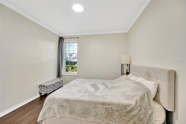 bedroom featuring dark wood-style floors, baseboards, and ornamental molding