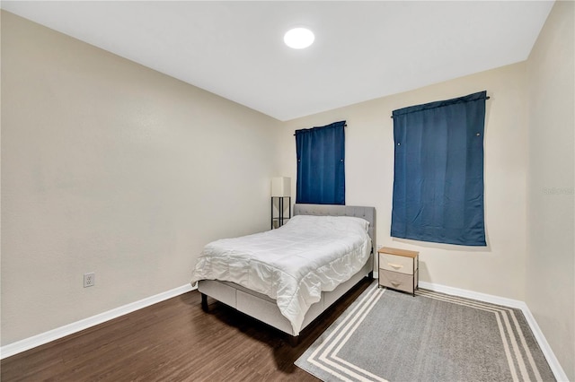 bedroom featuring dark wood-type flooring and baseboards