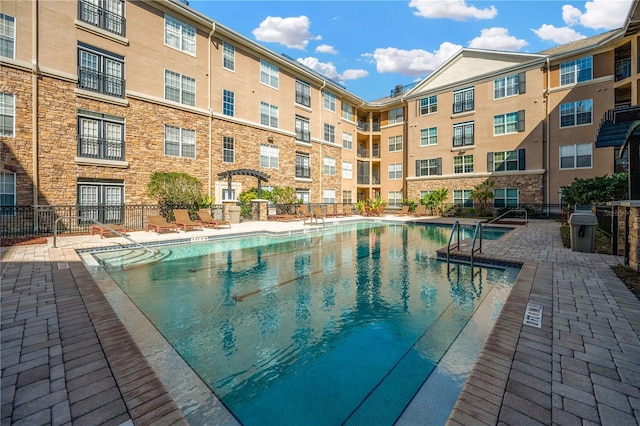 community pool featuring a patio area and fence