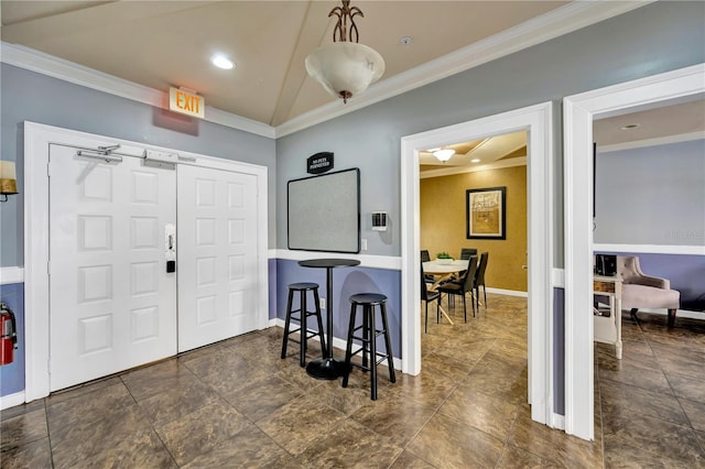 foyer featuring baseboards, vaulted ceiling, and crown molding