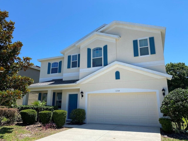 view of front facade featuring a garage, driveway, and stucco siding