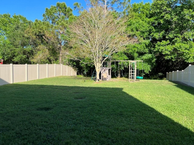 view of yard with a fenced backyard, an outdoor structure, and a storage shed