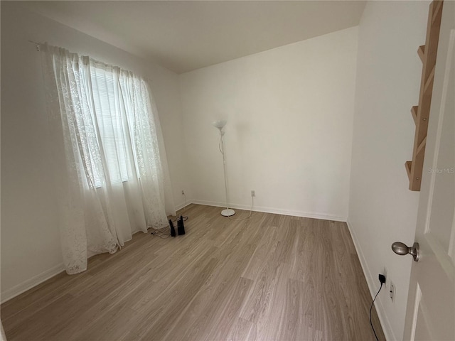 unfurnished room featuring baseboards and wood finished floors