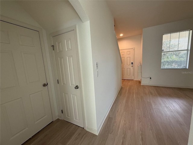 corridor with wood finished floors and baseboards