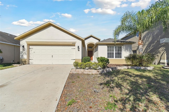 ranch-style home with driveway, an attached garage, and stucco siding