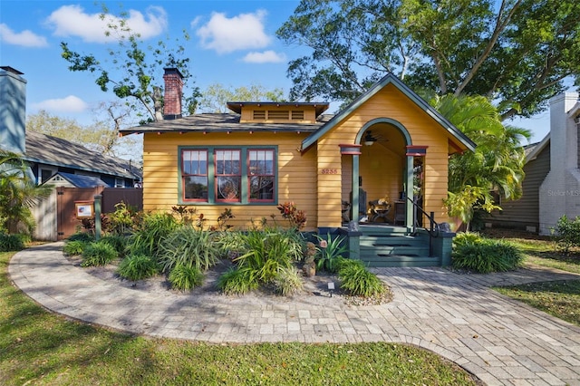 view of front of home with a chimney and fence