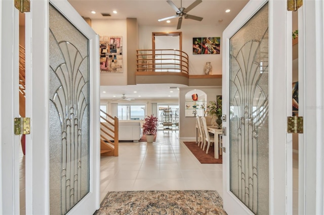 tiled entryway featuring recessed lighting, a ceiling fan, a towering ceiling, stairs, and visible vents