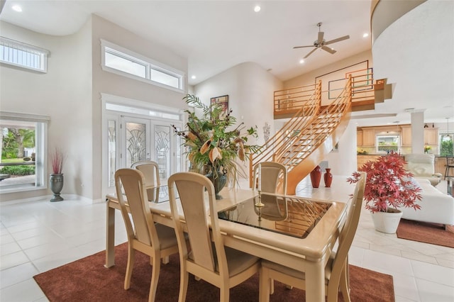 dining area featuring light tile patterned floors, baseboards, a towering ceiling, stairway, and recessed lighting