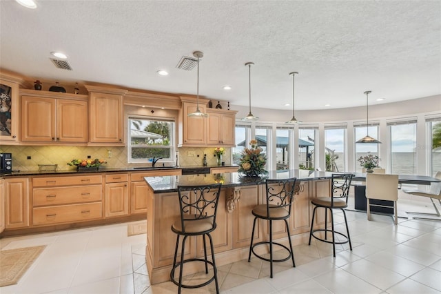 kitchen featuring a kitchen island, visible vents, and a kitchen breakfast bar