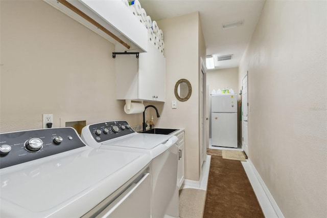 laundry area featuring carpet flooring, a sink, baseboards, cabinet space, and washing machine and clothes dryer