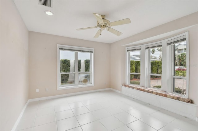 unfurnished room with a healthy amount of sunlight, baseboards, and visible vents