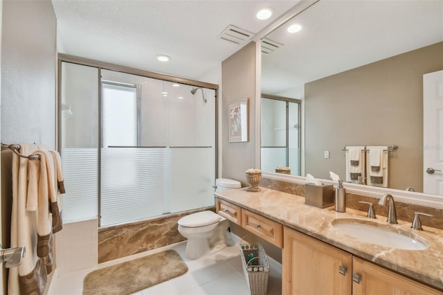 bathroom featuring shower / bath combination with glass door, visible vents, toilet, vanity, and tile patterned floors