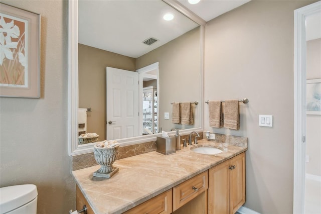 bathroom featuring toilet, visible vents, and vanity