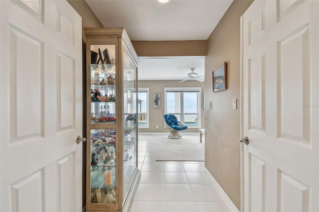 entrance foyer with light tile patterned floors, ceiling fan, and baseboards