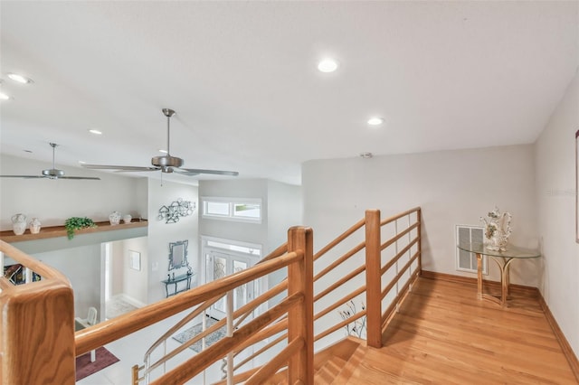 corridor with recessed lighting, visible vents, baseboards, an upstairs landing, and light wood finished floors