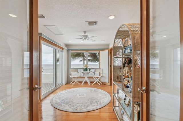 sunroom with visible vents, a ceiling fan, and french doors