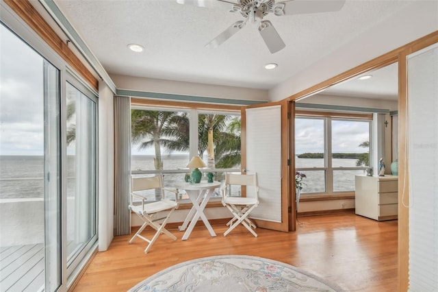 sunroom featuring a water view