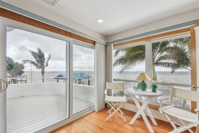 sunroom featuring a water view and visible vents