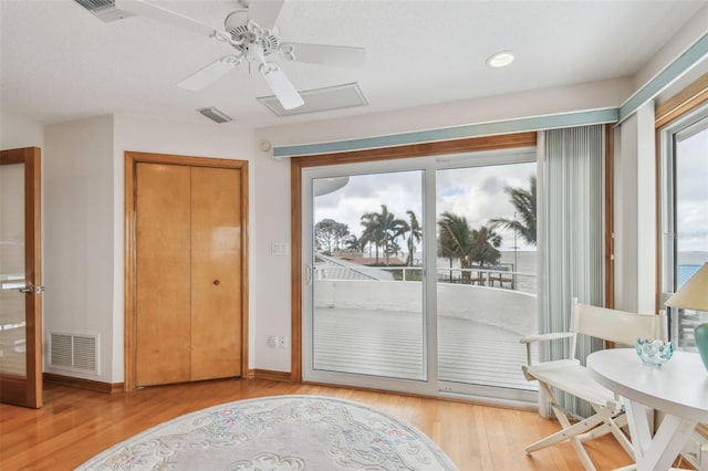 living area with visible vents, baseboards, and wood finished floors